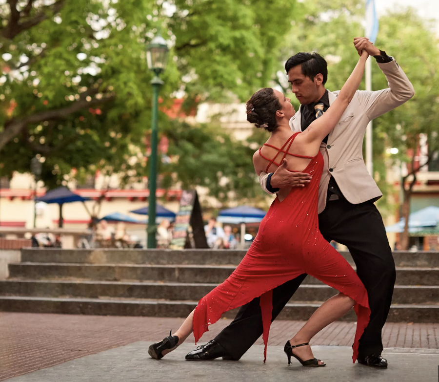 Professional salsa dancers dancing in a park.